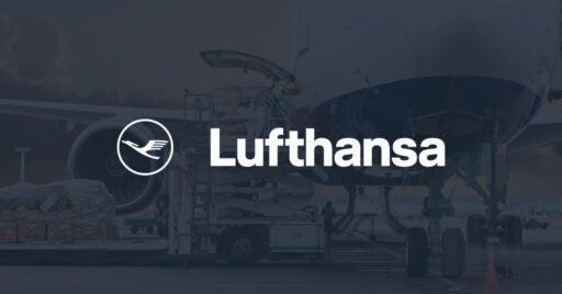 Bild einer Person, die Fracht in die Seite eines großen Flugzeugs lädt, mit Lufthansa-Logo-Overlay.