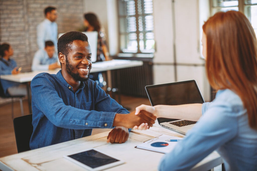 Entrevista a un candidato para un trabajo de aseguramiento de la calidad del software en una oficina de concepto abierto.