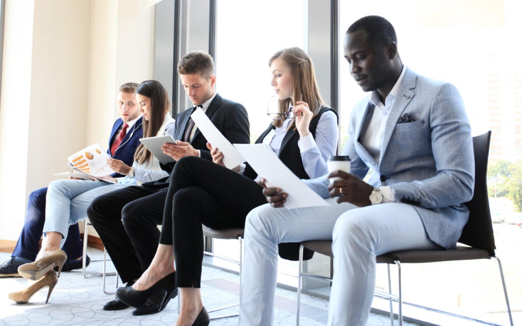 Candidates reviewing QA interview questions before a job interview.