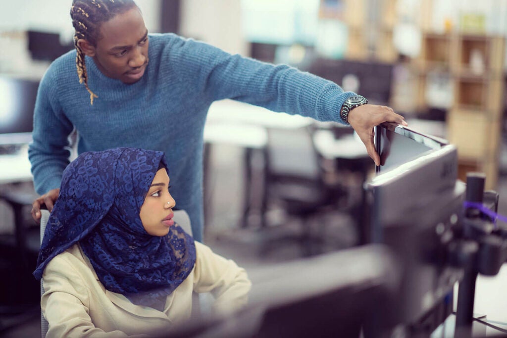 Bild von zwei Programmierern an einem Computer, die an TDM-Prozessen arbeiten.