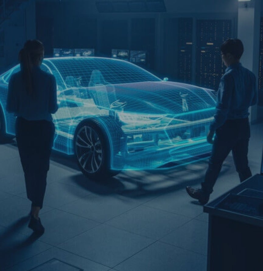 Image of a dimmed testing room for a vehicle with embedded software shown in transparent blue with embedded engineers walking toward it.