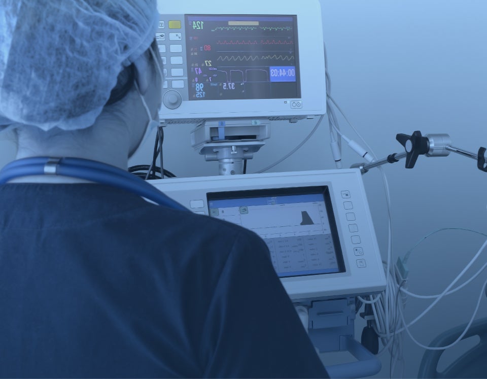 Image of a medical professional looking at the medical stats displayed on a patient