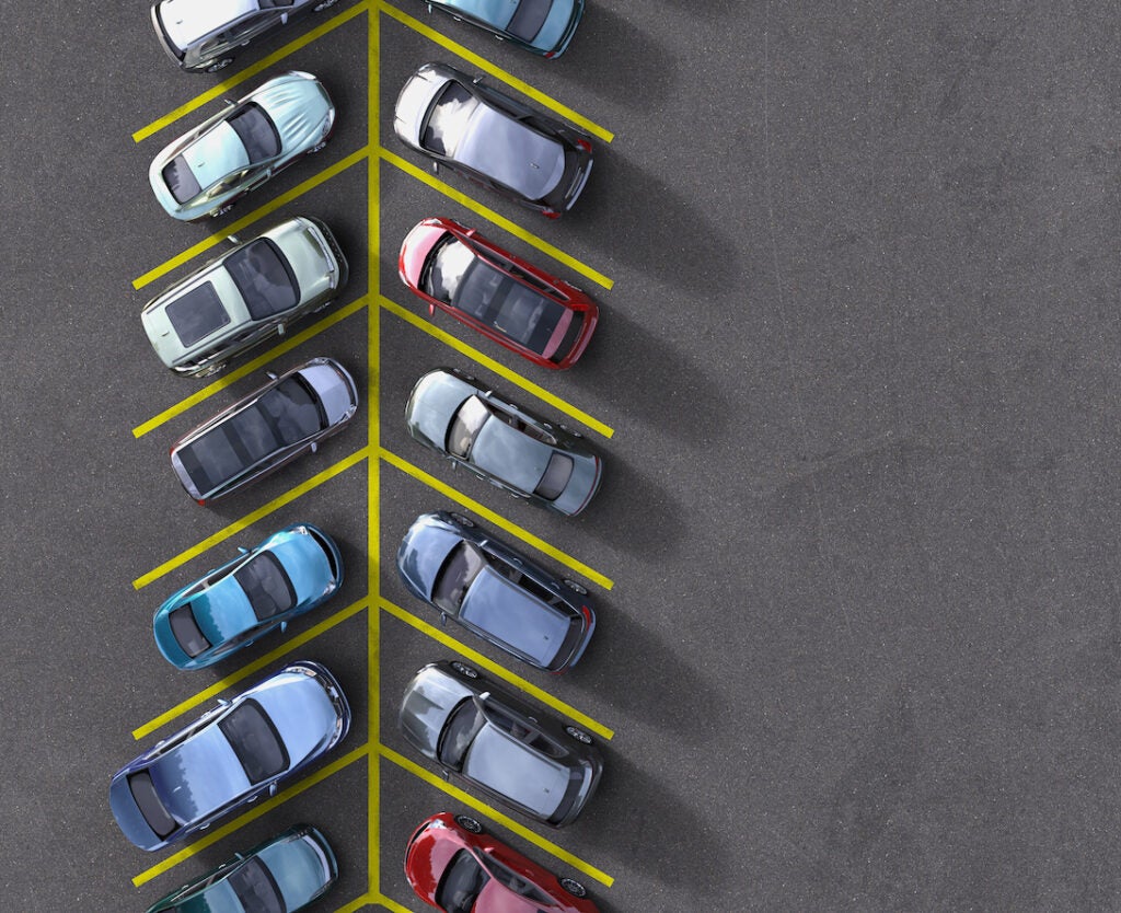 Birdseye view of a variety of cars parked in a parking lot.